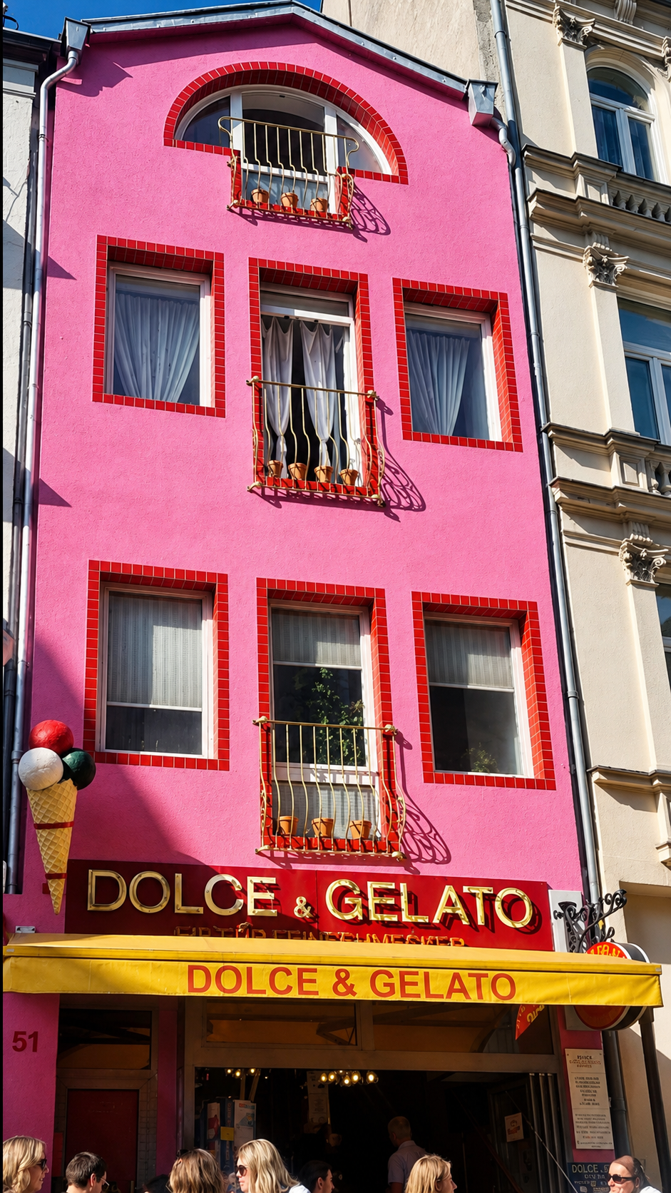 Die markante pinke Fassade von Dolce & Gelato in der Pfeilstraße 51 in Köln mit gelber Markise, goldener Schrift und großem Eistüten-Modell